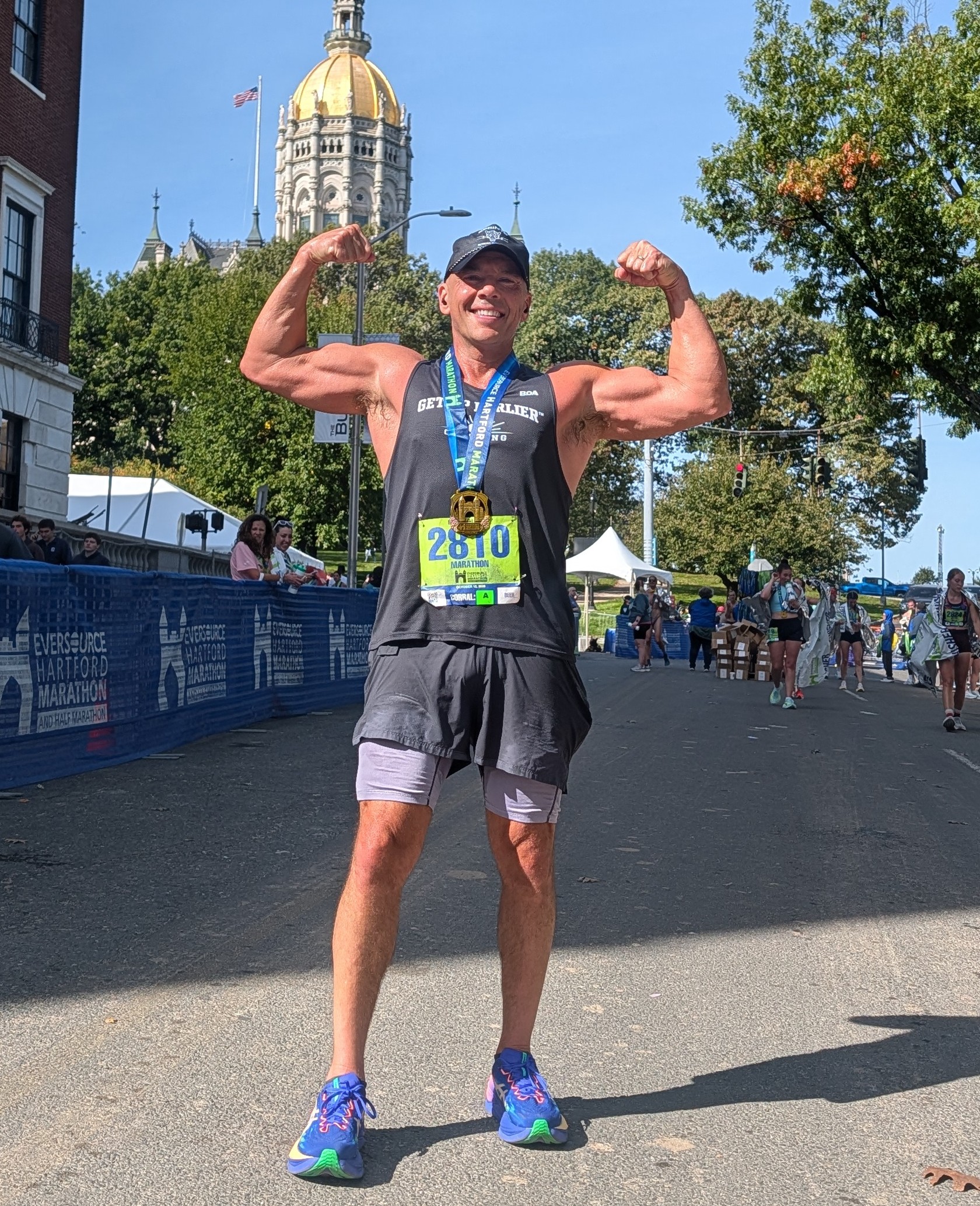Michael Baker celebrating his 2026 Hartford Marathon finish at age 51, wearing bib 2810