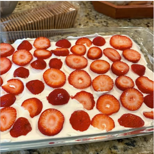 Sliced strawberries arranged over fresh whipped cream for the icebox cake