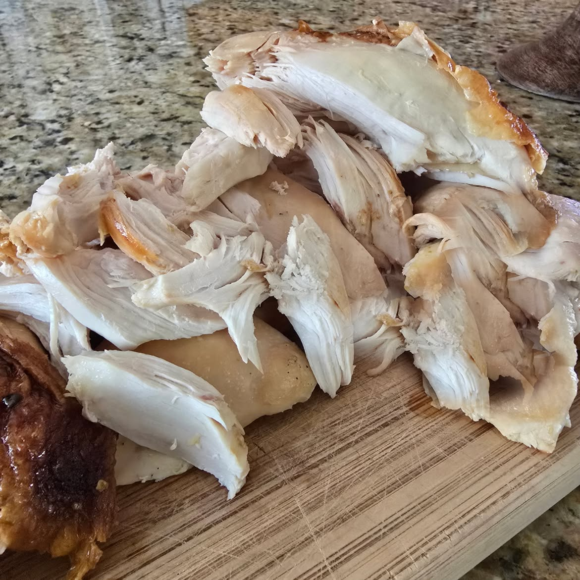 Pulled rotisserie chicken on a cutting board